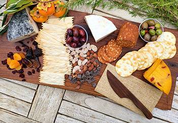 vegan charcuterie board with crackers, olives, fruits, and vegan cheese