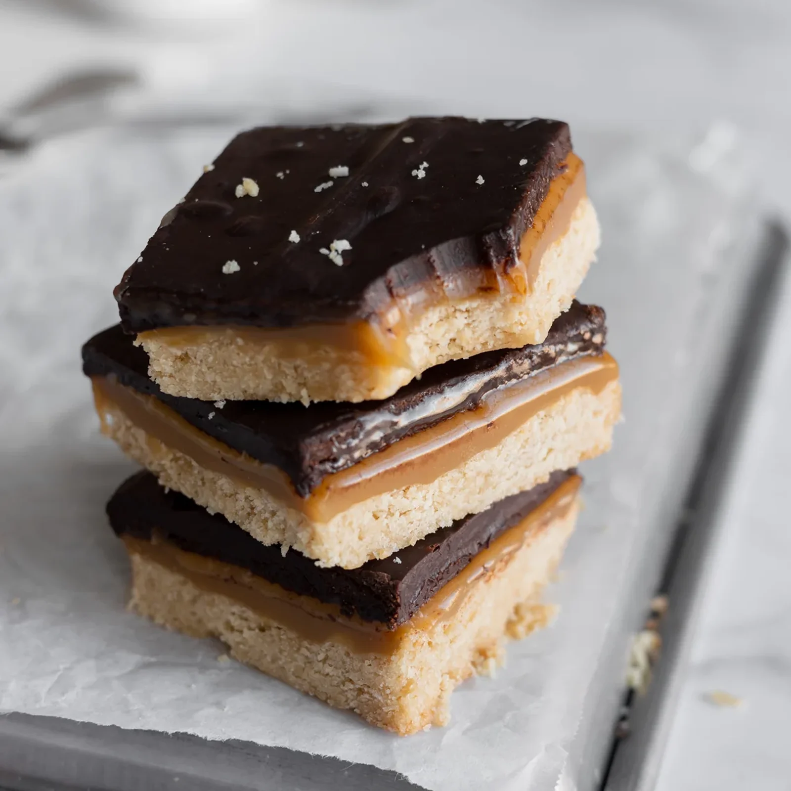 vegan millionaire bars stacked on top of each other, one with a bite taken out of it