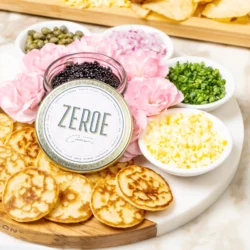 vegan plant-based caviar on a blini board with four bowls of various toppings