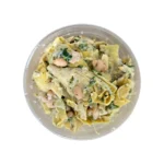 a deli container filled with vegan plant based artichoke and white bean salad by the vreamery