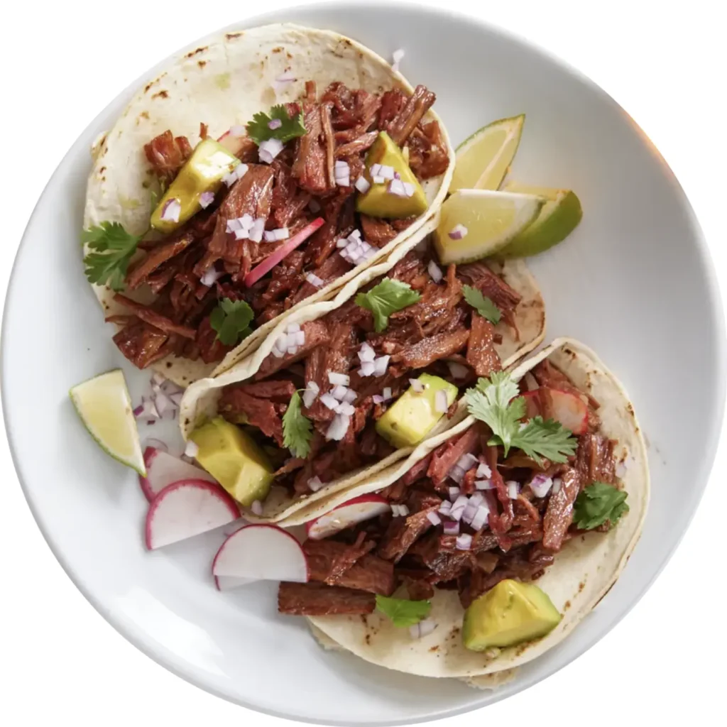 Vegan plant-based pulled steak in three tacos with avocado lime and radish on a white plate
