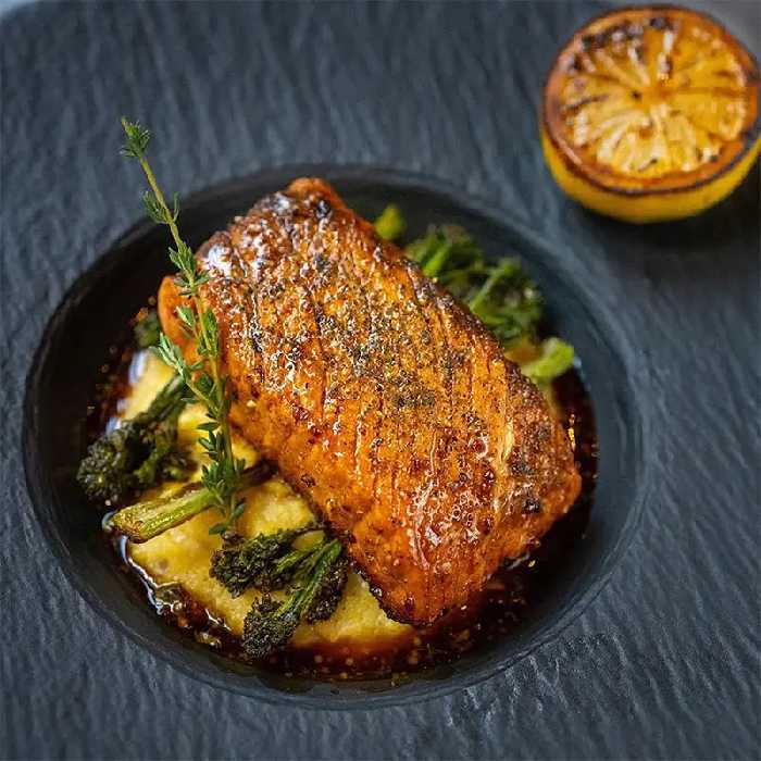 Vegan plant-based salmon filet on a plate with charred lemon