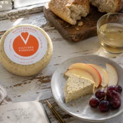 Pepper Jill cashew cheese served on a plate with fruit and bread
