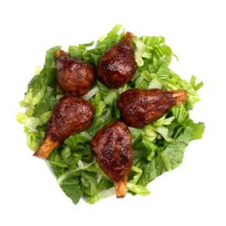 five vegan chicken drumsticks fanned out on a pile of shredded lettuce
