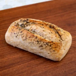 a vegan sourdough mini loaf green goddess flavor on a wood board